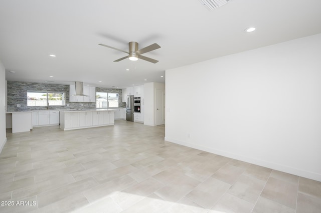 unfurnished living room featuring ceiling fan