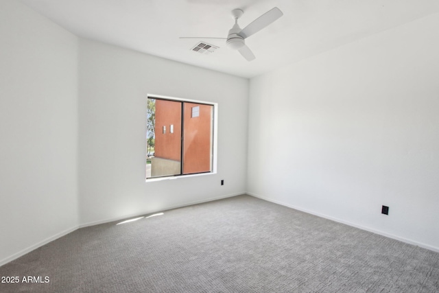 carpeted spare room featuring a ceiling fan and baseboards