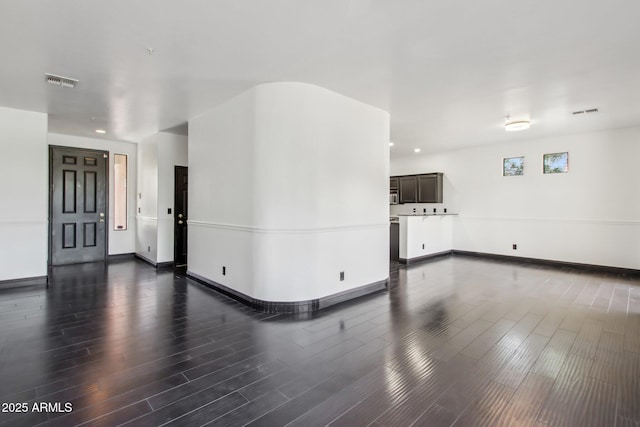 unfurnished living room featuring dark wood-style flooring, baseboards, and recessed lighting