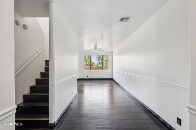 interior space with dark wood-style floors, stairway, and baseboards
