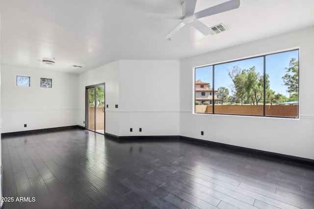 unfurnished room featuring a ceiling fan, dark wood finished floors, and baseboards