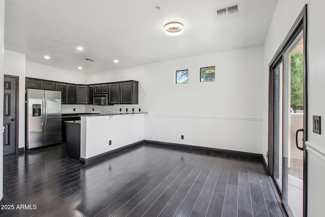 kitchen featuring stainless steel appliances, plenty of natural light, a peninsula, dark wood-type flooring, and recessed lighting