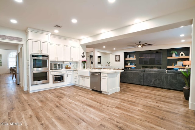 kitchen featuring kitchen peninsula, sink, ceiling fan, appliances with stainless steel finishes, and white cabinetry