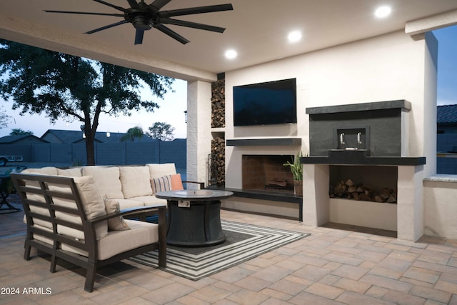 view of patio / terrace with an outdoor living space with a fireplace and ceiling fan