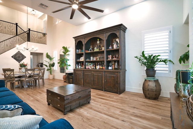 living room featuring plenty of natural light, light hardwood / wood-style floors, and ceiling fan with notable chandelier