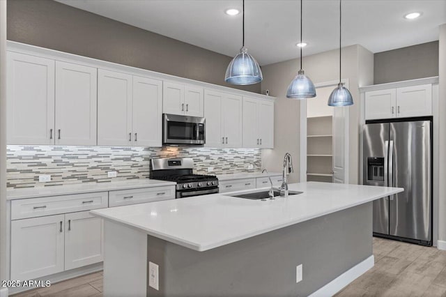 kitchen with stainless steel appliances, sink, hanging light fixtures, and white cabinets