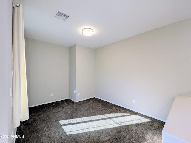 empty room featuring dark colored carpet