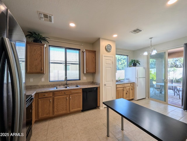 kitchen with hanging light fixtures, plenty of natural light, sink, and black appliances