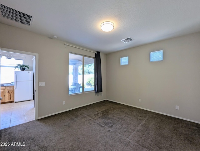 unfurnished room featuring a healthy amount of sunlight and carpet