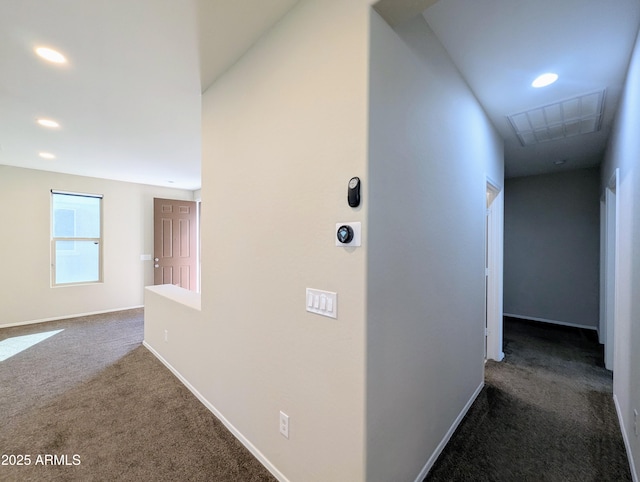 hall with dark colored carpet