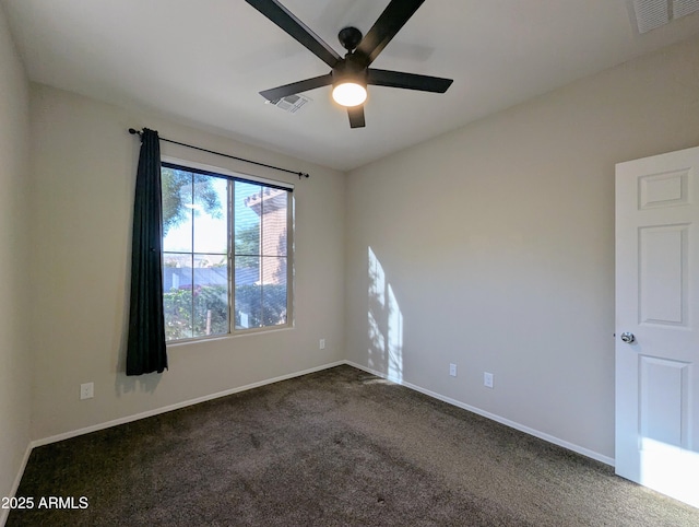 empty room featuring ceiling fan and dark carpet