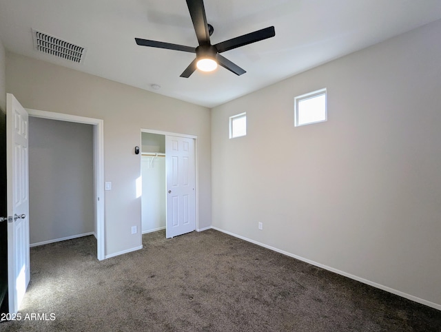 unfurnished bedroom featuring dark carpet, ceiling fan, and a closet