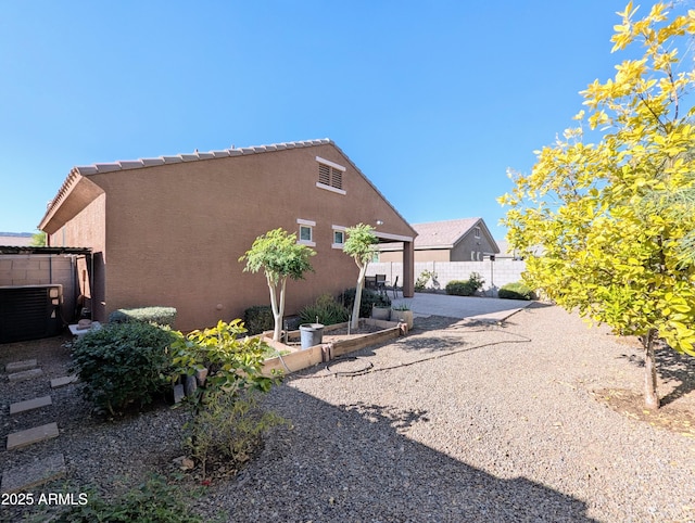 view of property exterior with central AC unit and a patio