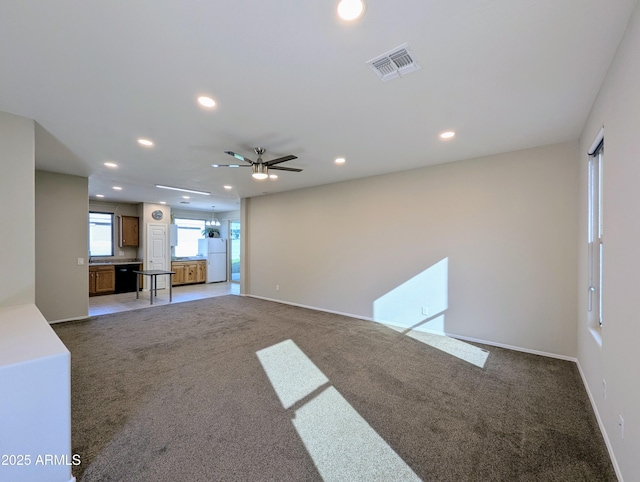 unfurnished living room with light carpet and ceiling fan