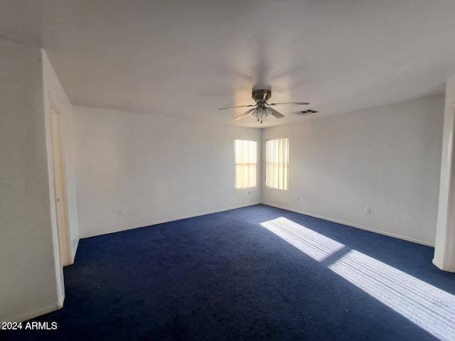 empty room featuring dark carpet and ceiling fan