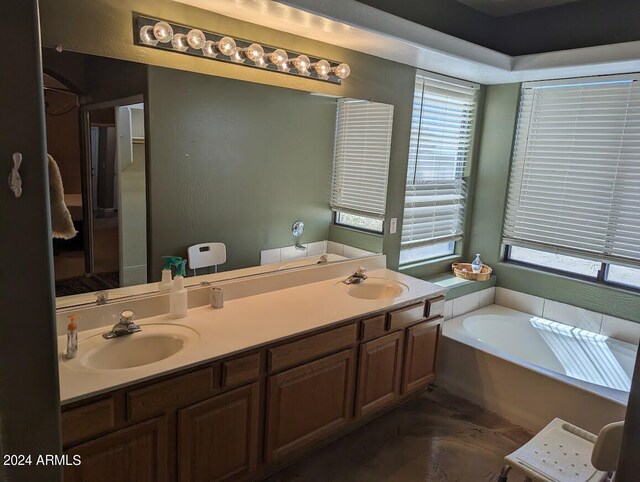 bathroom featuring dual vanity and a bathtub