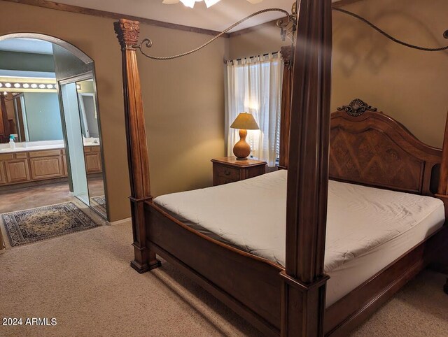 bedroom with ensuite bath and dark colored carpet