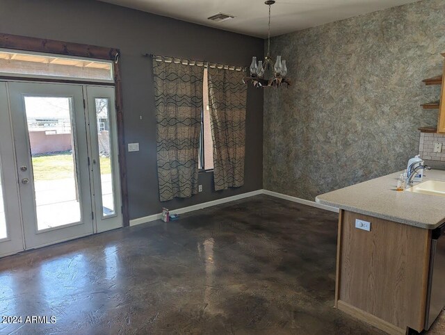 unfurnished dining area featuring an inviting chandelier and sink