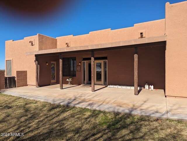 back of property with a patio area and a yard