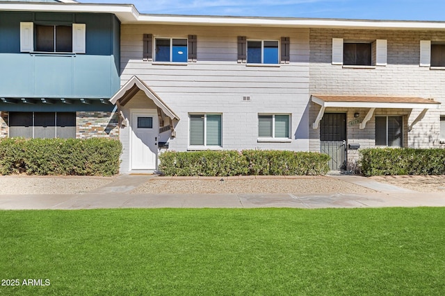 view of front of house with a front yard and brick siding