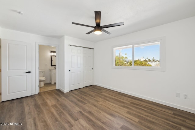 unfurnished bedroom with a closet, a ceiling fan, connected bathroom, wood finished floors, and baseboards