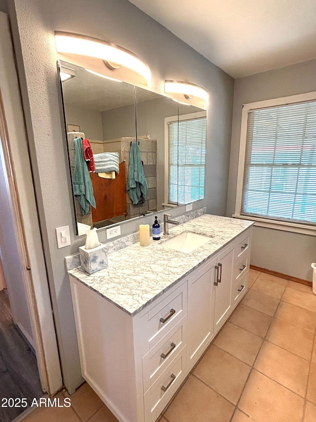 bathroom with vanity, tile patterned flooring, and a healthy amount of sunlight