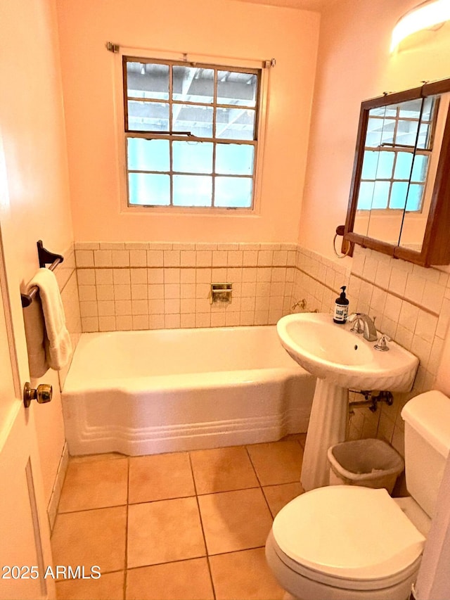 bathroom featuring a bathtub, tile patterned flooring, and toilet