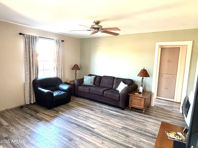 living room with dark hardwood / wood-style flooring and ceiling fan