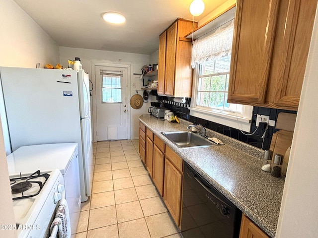 kitchen featuring white range with gas cooktop, light tile patterned floors, a wealth of natural light, sink, and black dishwasher