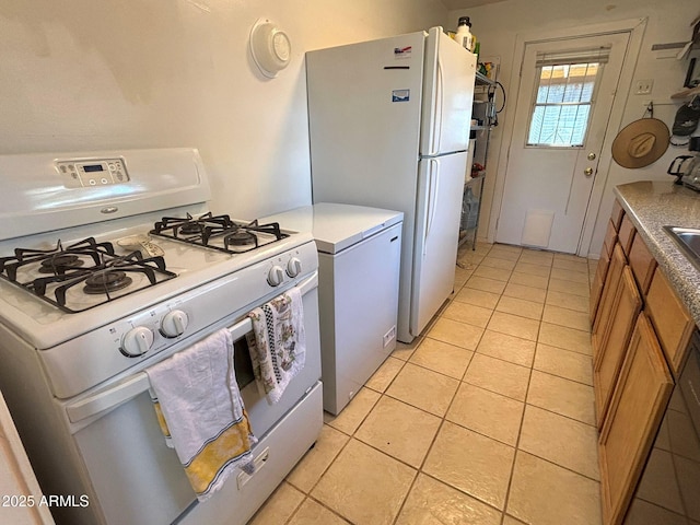 kitchen with white appliances and light tile patterned floors