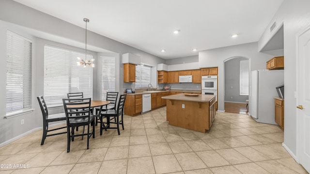 3411 S Vine St, Chandler, AZ 85248 - kitchen featuring visible vents, a center island, a sink, white appliances, and brown cabinetry