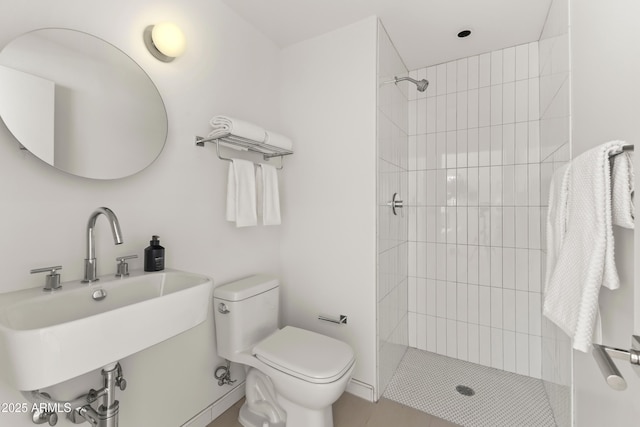 full bath featuring a sink, a tile shower, and toilet