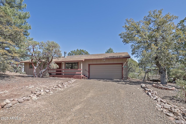 view of front of property with an attached garage and dirt driveway