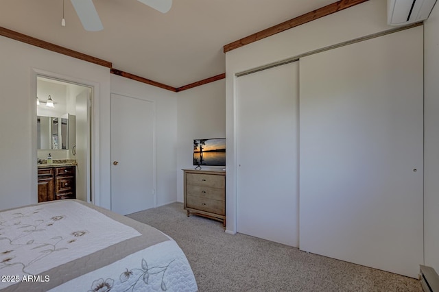 bedroom with ornamental molding, ensuite bathroom, a closet, carpet floors, and ceiling fan