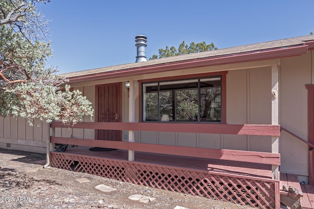 entrance to property featuring crawl space and roof with shingles