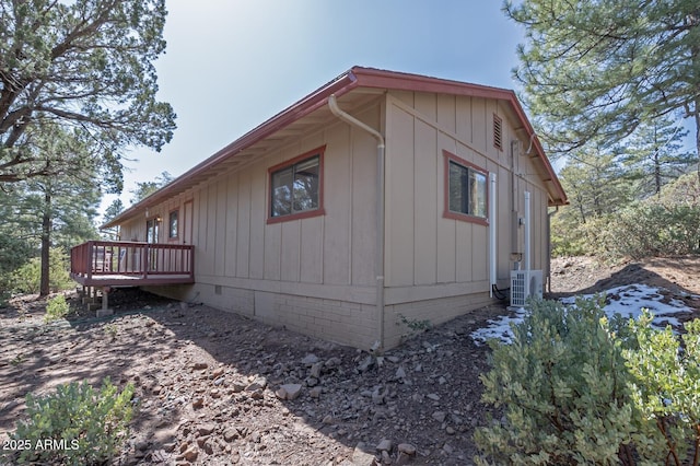 view of side of property featuring crawl space, a wooden deck, and ac unit