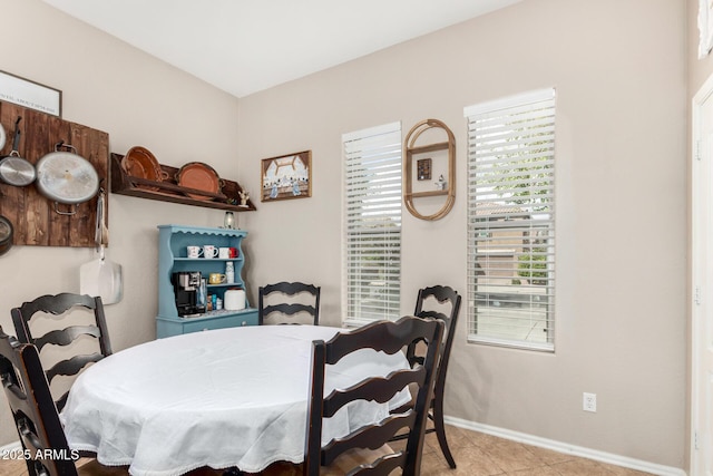 tiled dining area featuring baseboards