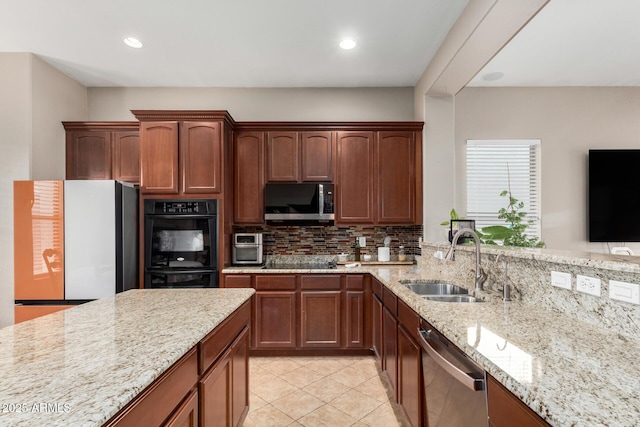 kitchen with light stone counters, light tile patterned flooring, a sink, decorative backsplash, and stainless steel appliances