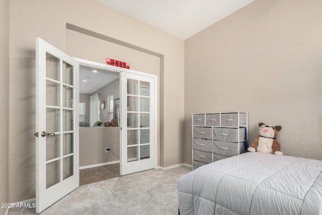 carpeted bedroom featuring french doors and baseboards