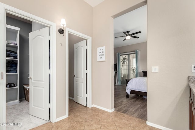 hallway with light tile patterned flooring and baseboards