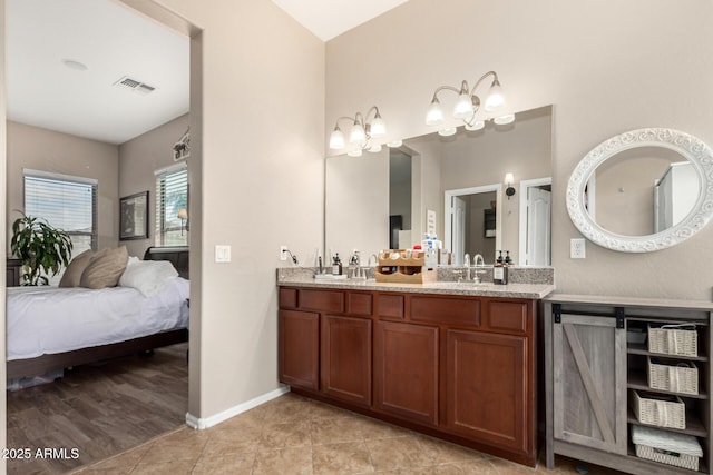 full bath with visible vents, a sink, connected bathroom, double vanity, and baseboards