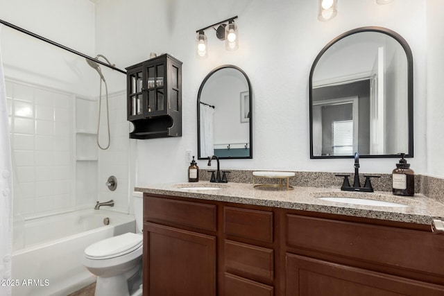 full bathroom featuring double vanity, toilet, washtub / shower combination, and a sink