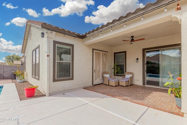 exterior space with a ceiling fan, a patio area, fence, and stucco siding