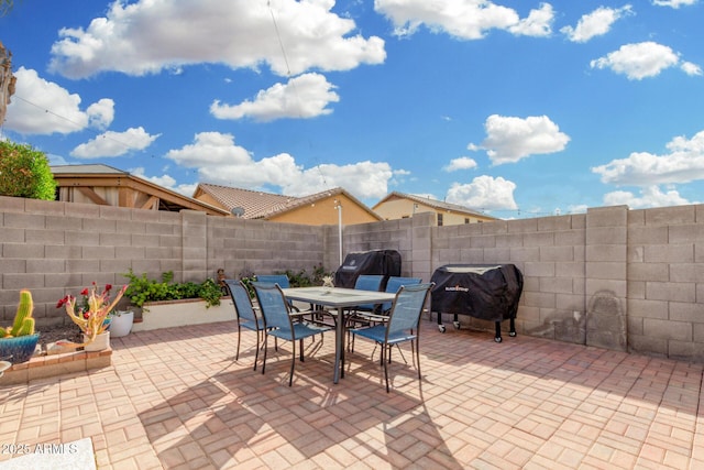 view of patio / terrace with outdoor dining area, a grill, and a fenced backyard