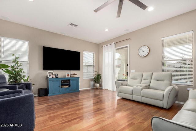 living room with a ceiling fan, visible vents, baseboards, light wood-style flooring, and recessed lighting