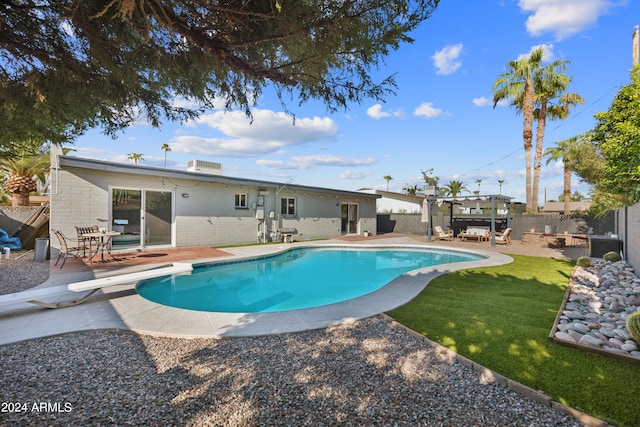 view of pool featuring a yard, a diving board, and a patio