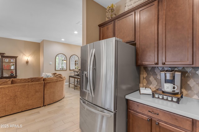10650 E Palladium Dr, Mesa, AZ 85212 - kitchen featuring stainless steel fridge with ice dispenser, open floor plan, light wood-type flooring, light countertops, and backsplash