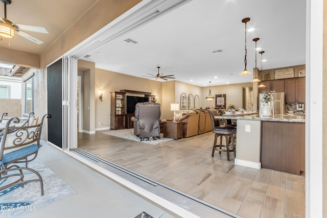 10650 E Palladium Dr, Mesa, AZ 85212 - kitchen featuring a ceiling fan, freestanding refrigerator, a kitchen breakfast bar, and open floor plan
