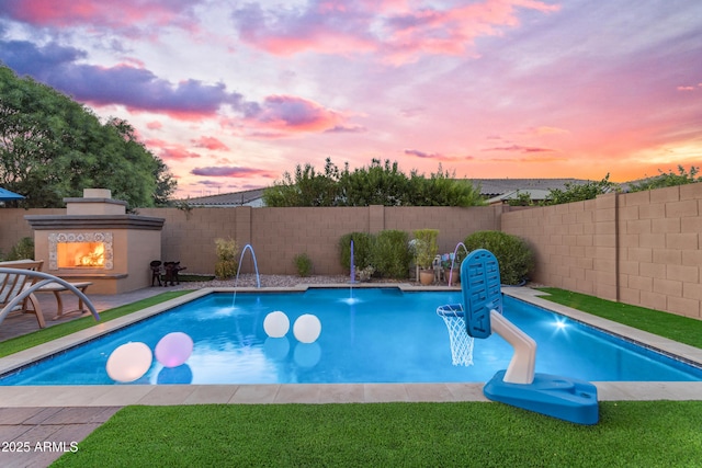 10650 E Palladium Dr, Mesa, AZ 85212 - view of swimming pool featuring a lit fireplace, a fenced backyard, and a patio area