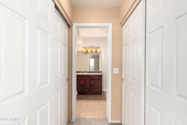 hallway featuring sink and light tile patterned floors